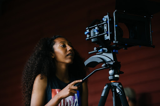 African-American Deaf youth filmmaker operating a movie camera.